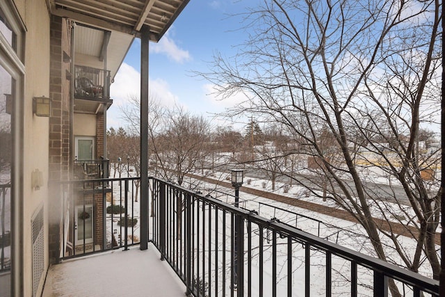 view of snow covered back of property