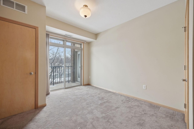 spare room with visible vents, light carpet, and baseboards