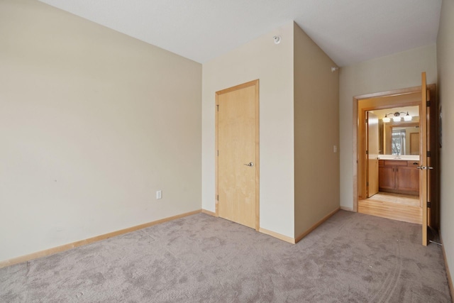 unfurnished bedroom with light carpet and baseboards