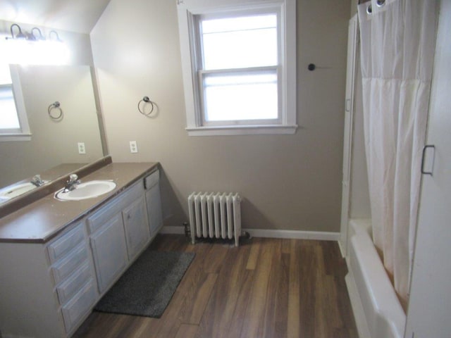 bathroom with vanity, hardwood / wood-style flooring, radiator heating unit, and shower / tub combo with curtain