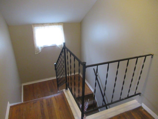 staircase featuring hardwood / wood-style flooring and vaulted ceiling