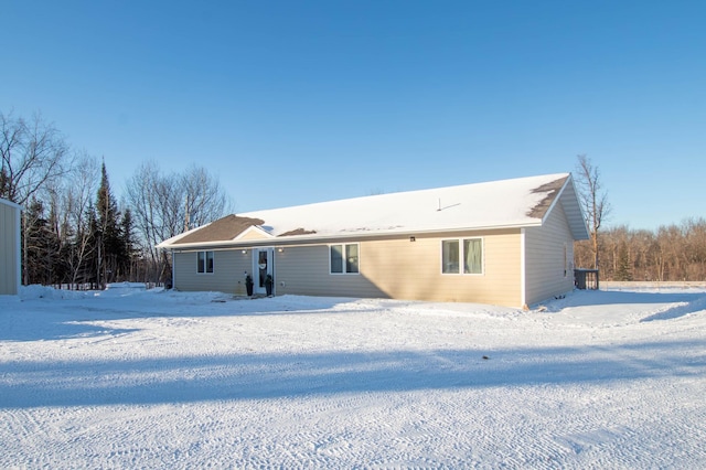 view of snow covered rear of property