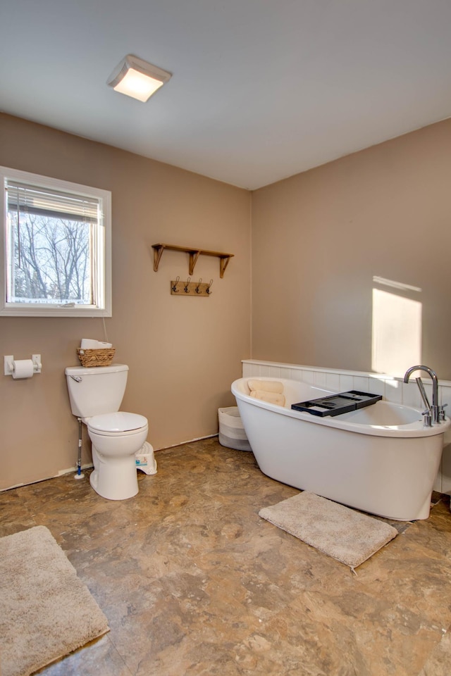 bathroom with a bathing tub and toilet