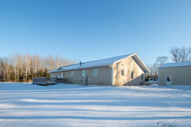 snow covered house with a deck