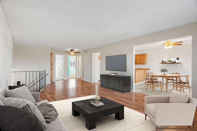 living room featuring ceiling fan and light hardwood / wood-style floors