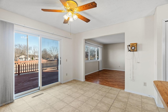 empty room with ceiling fan and a textured ceiling