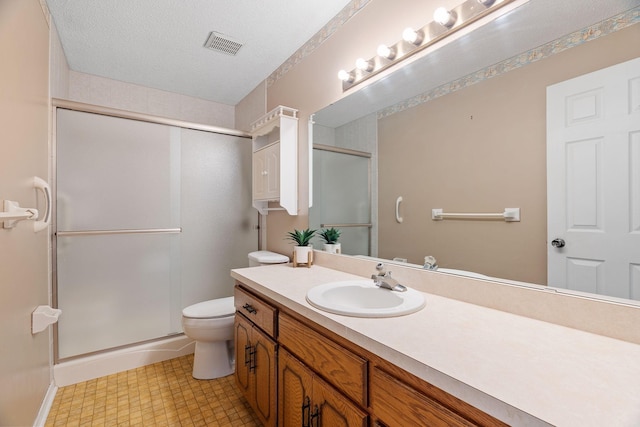 bathroom featuring walk in shower, vanity, toilet, and a textured ceiling