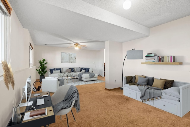 carpeted living room featuring ceiling fan and a textured ceiling