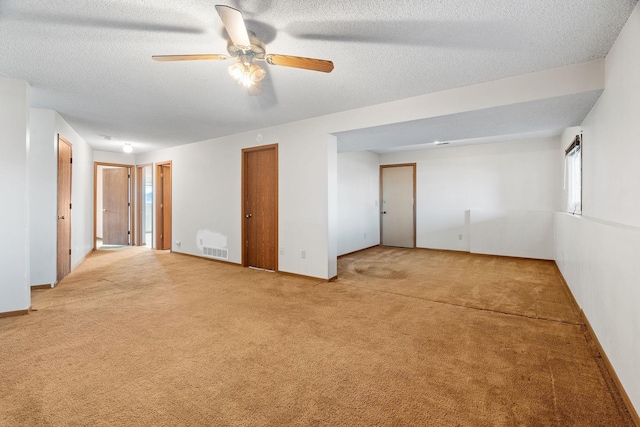 unfurnished room featuring ceiling fan, light colored carpet, and a textured ceiling