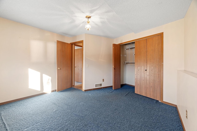 unfurnished bedroom featuring dark carpet, a closet, and a textured ceiling