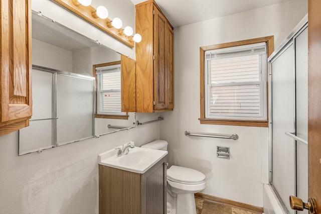 full bathroom featuring vanity, combined bath / shower with glass door, and toilet