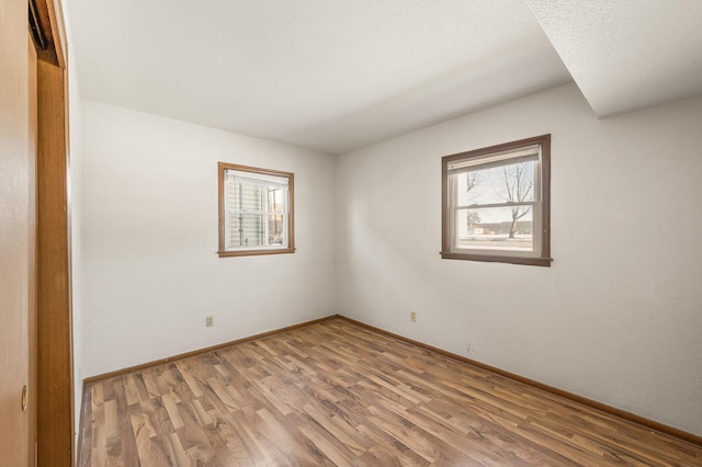 spare room with wood-type flooring and a textured ceiling