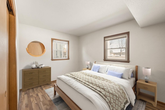 bedroom with hardwood / wood-style floors and a textured ceiling