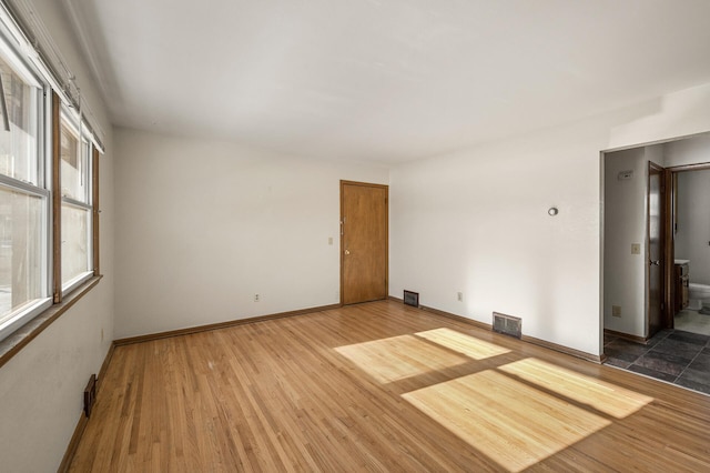 unfurnished room featuring plenty of natural light and hardwood / wood-style floors