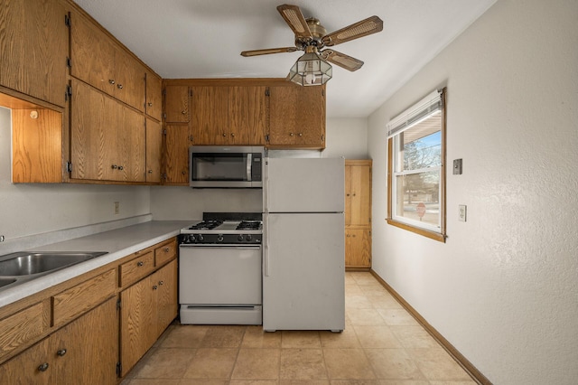 kitchen with ceiling fan, white appliances, and sink