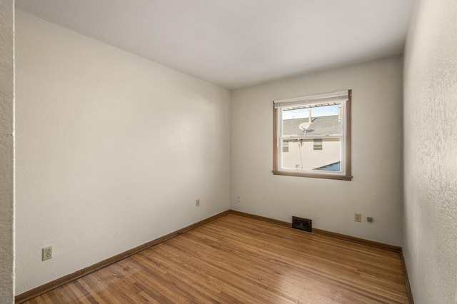 spare room featuring wood-type flooring