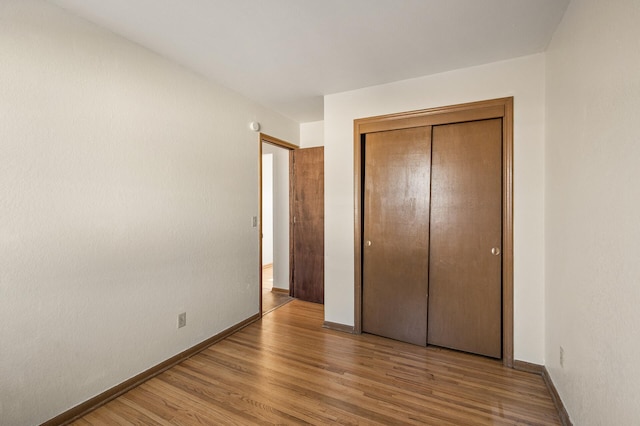 unfurnished bedroom featuring a closet and light wood-type flooring