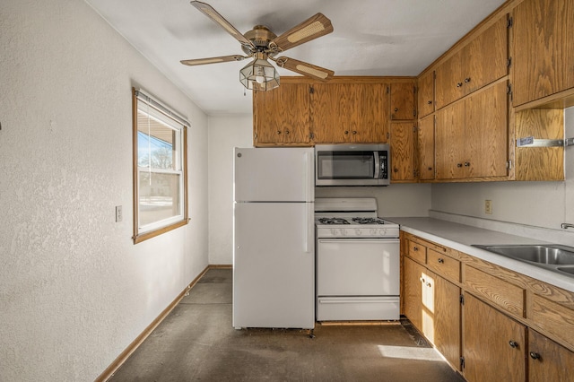 kitchen featuring ceiling fan, white appliances, and sink