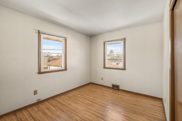 unfurnished room featuring plenty of natural light and light hardwood / wood-style floors