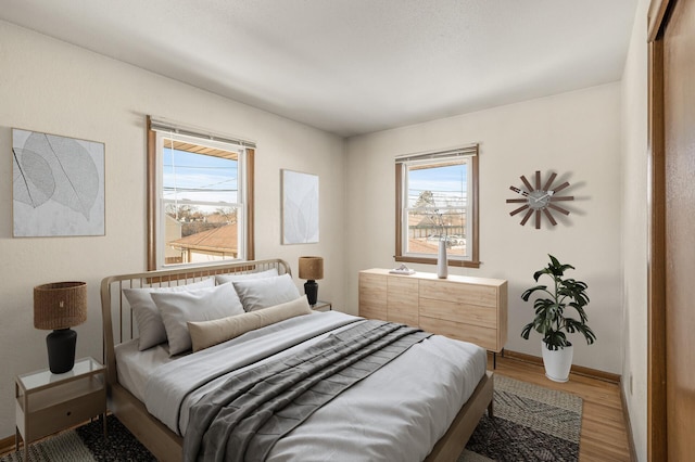 bedroom with multiple windows and wood-type flooring