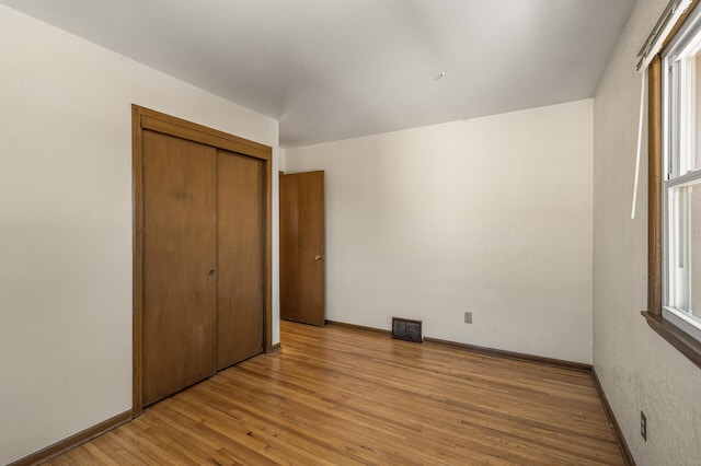 unfurnished bedroom featuring a closet and light wood-type flooring