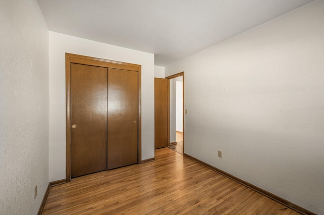 unfurnished bedroom with a closet and light hardwood / wood-style flooring