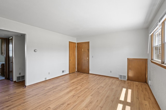 spare room featuring light wood-style flooring and baseboards