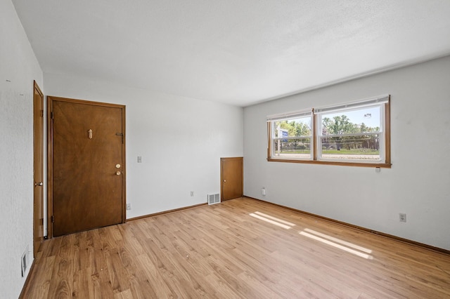 unfurnished room featuring light wood-type flooring and baseboards