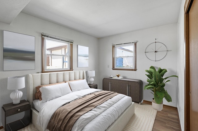 bedroom with wood finished floors and baseboards