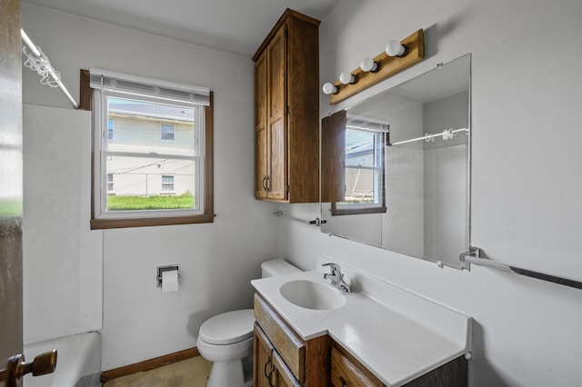 bathroom featuring toilet, vanity, plenty of natural light, and a shower