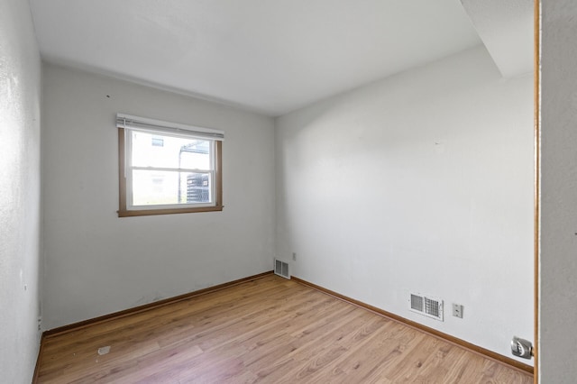 spare room with light wood finished floors and baseboards
