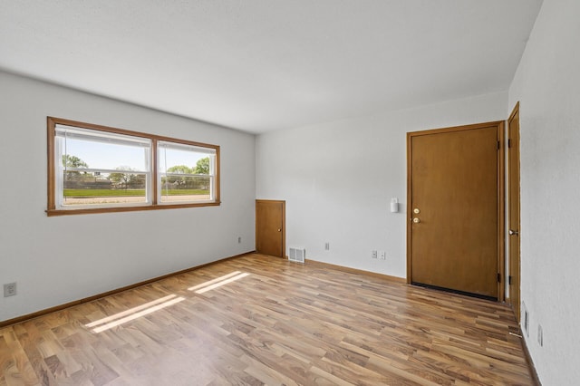 empty room featuring wood finished floors and baseboards