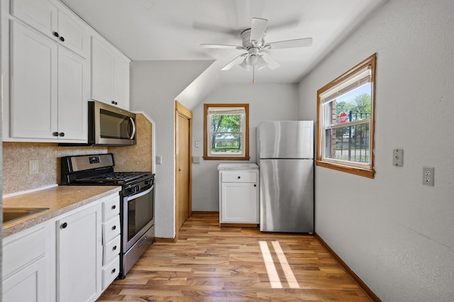 kitchen with stainless steel appliances, light wood-type flooring, white cabinetry, a ceiling fan, and light countertops
