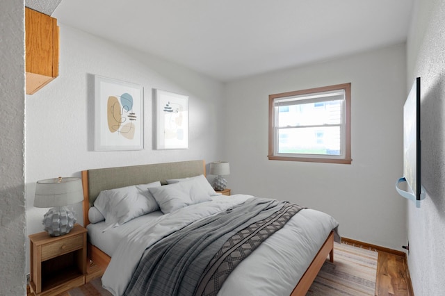 bedroom featuring wood finished floors and baseboards