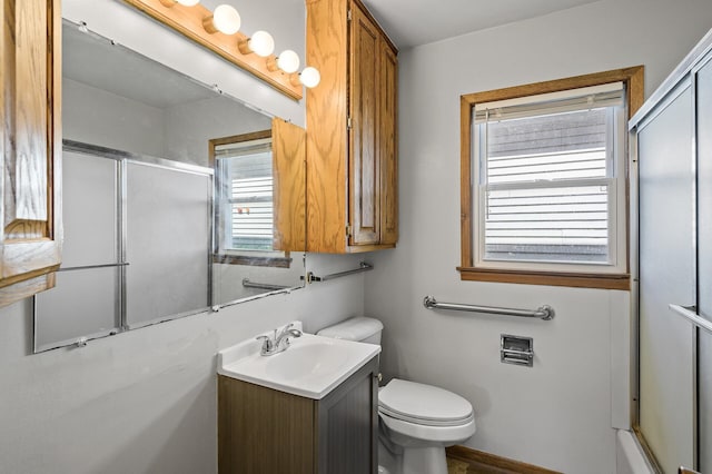 bathroom with a shower with shower door, toilet, and vanity