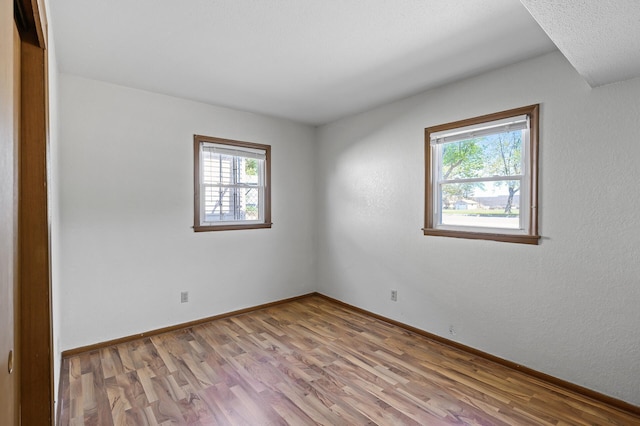 unfurnished room with wood finished floors and baseboards
