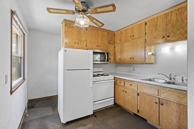 kitchen with white appliances, a sink, a ceiling fan, light countertops, and baseboards