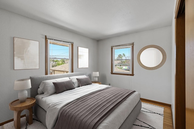 bedroom featuring baseboards and wood finished floors