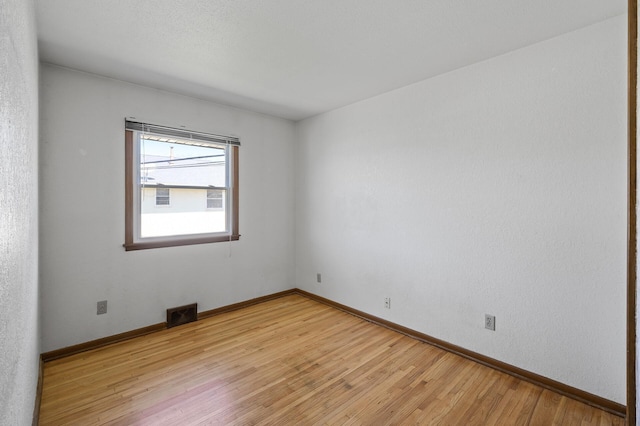 unfurnished room with light wood finished floors and baseboards