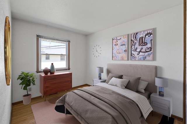 bedroom featuring wood finished floors and baseboards