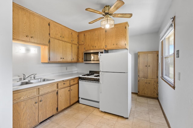 kitchen featuring white appliances, a sink, a ceiling fan, light countertops, and baseboards
