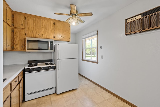 kitchen featuring white appliances, baseboards, ceiling fan, light countertops, and brown cabinetry