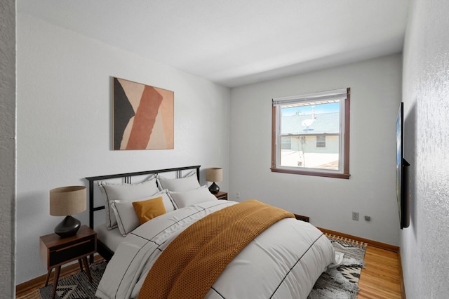 bedroom featuring wood finished floors and baseboards