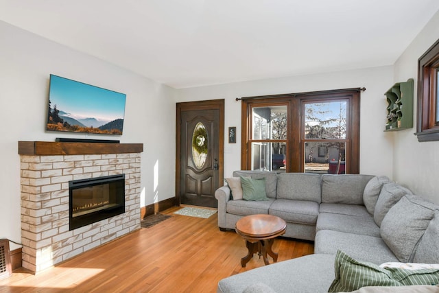 living room with hardwood / wood-style floors and a brick fireplace