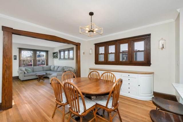 dining room featuring crown molding, a notable chandelier, and light hardwood / wood-style flooring