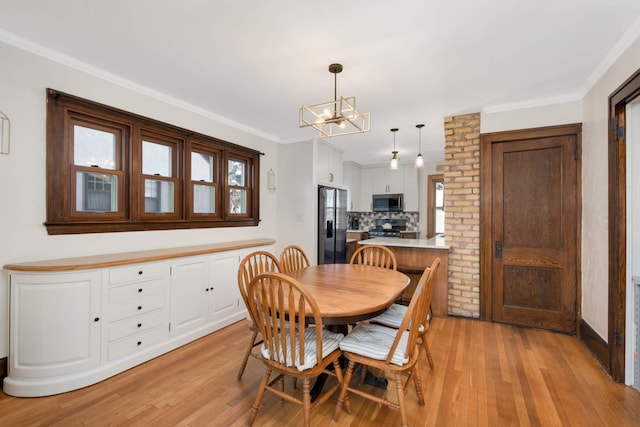 dining room with crown molding, a notable chandelier, and light hardwood / wood-style flooring