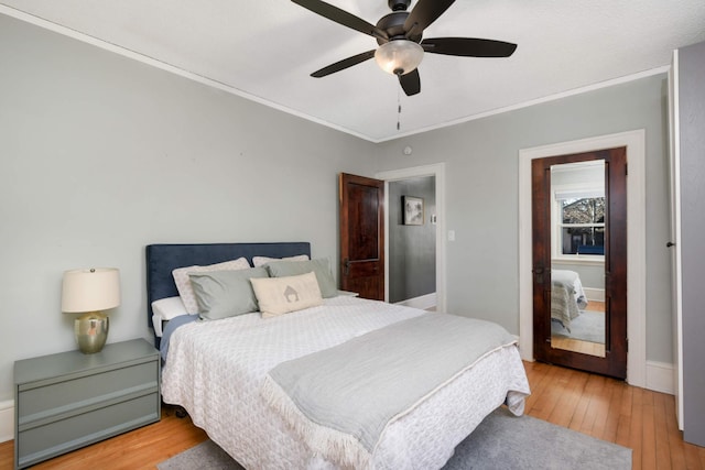 bedroom with crown molding, ceiling fan, and light hardwood / wood-style flooring