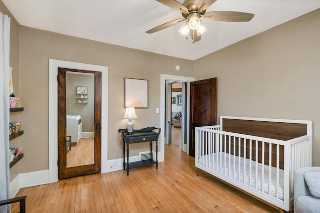 bedroom featuring ceiling fan, light hardwood / wood-style flooring, and a textured ceiling