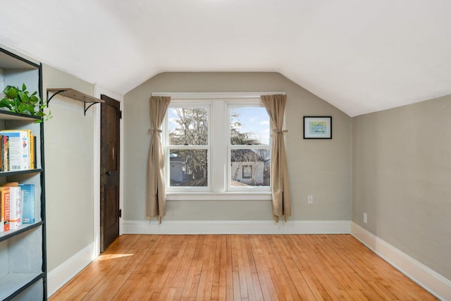 additional living space featuring lofted ceiling and light hardwood / wood-style flooring