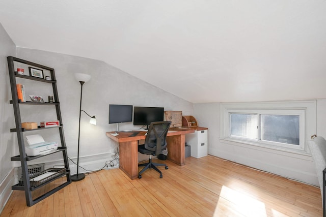 home office featuring lofted ceiling and light hardwood / wood-style floors